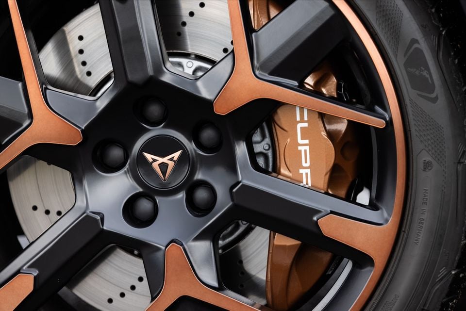 Close-up of a CUPRA alloy wheel with copper and dark grey finish, showing a branded copper brake caliper and drilled disc rotor