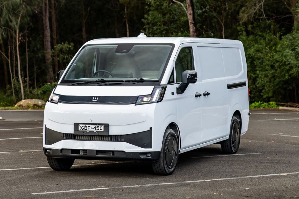 A white 2026 Farizon V7E electric panel van seen from the front-side in a car park, with trees in the background