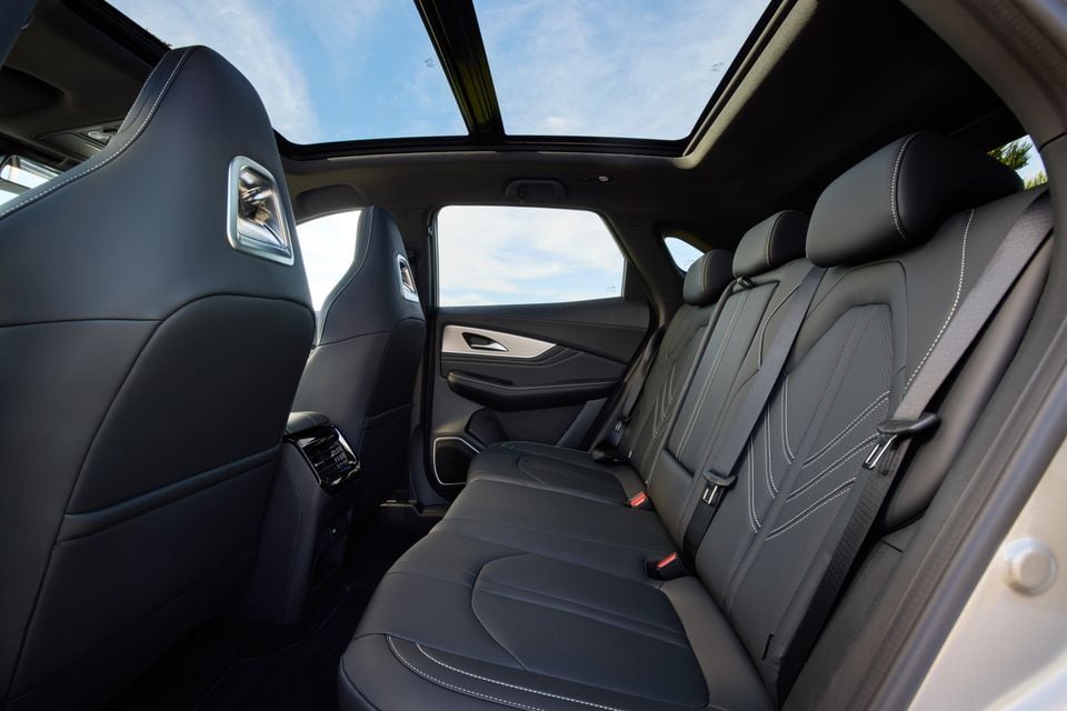 Rear interior of a Forthing Taikon 5 SUV showing black leather rear seats with white contrast stitching and a panoramic sunroof overhead