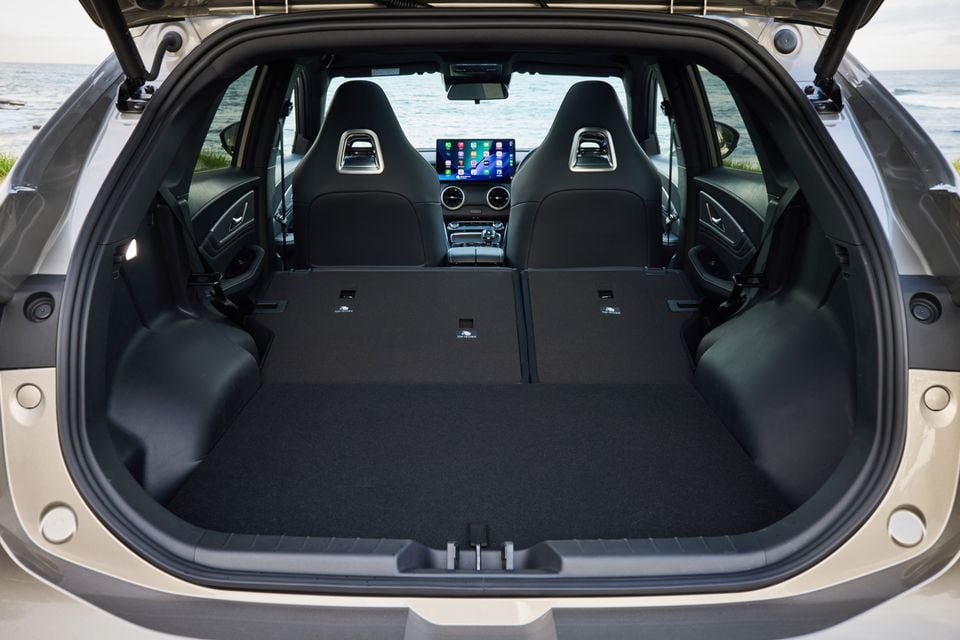 Boot of a Forthing Taikon 5 SUV with rear seats folded flat, showing a large cargo area, sport front seats and touchscreen infotainment display visible through the cabin.