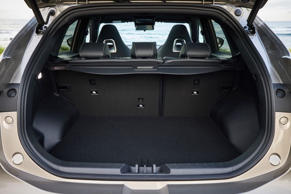 The open boot of a Forthing Taikon 5 SUV showing a large carpeted cargo area with a retractable cargo blind and top tether anchor points, with the rear seats visible through the opening