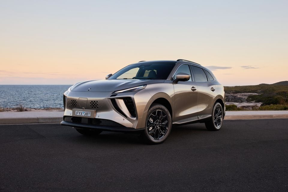 A silver Forthing Taikon 5 SUV parked near a coastal lookout at dusk, seen from the front-left angle