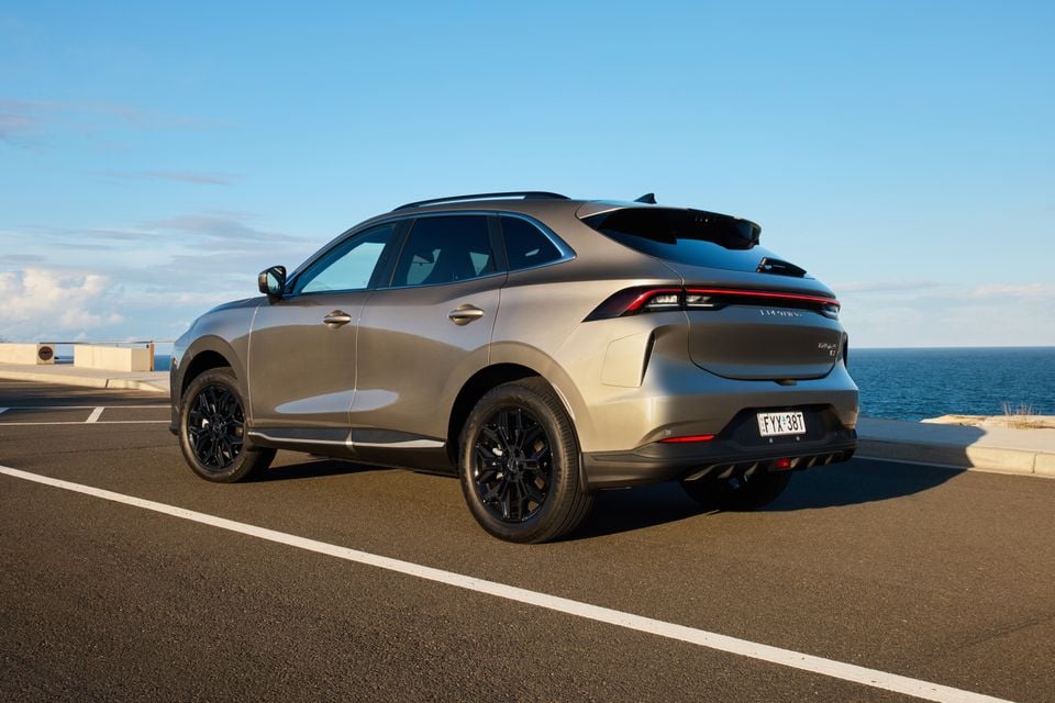 A grey Forthing Taikon 5 SUV seen from the rear three-quarter angle, parked near a coastal overlook with ocean views in the background