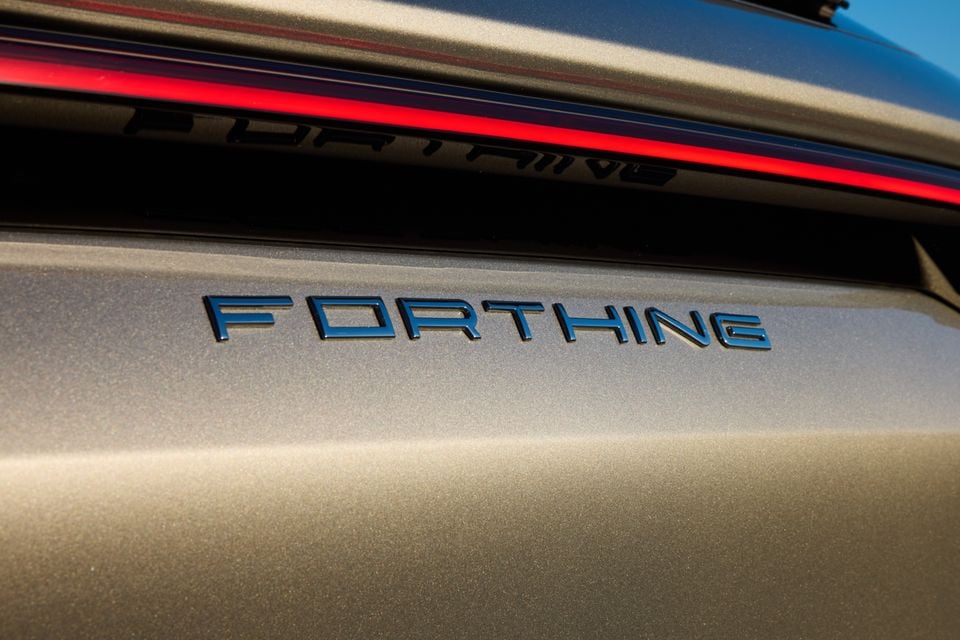 Close-up of the 'Forthing' name badge on the exterior panel of a Forthing Taikon 5, with a red tail-light strip visible above