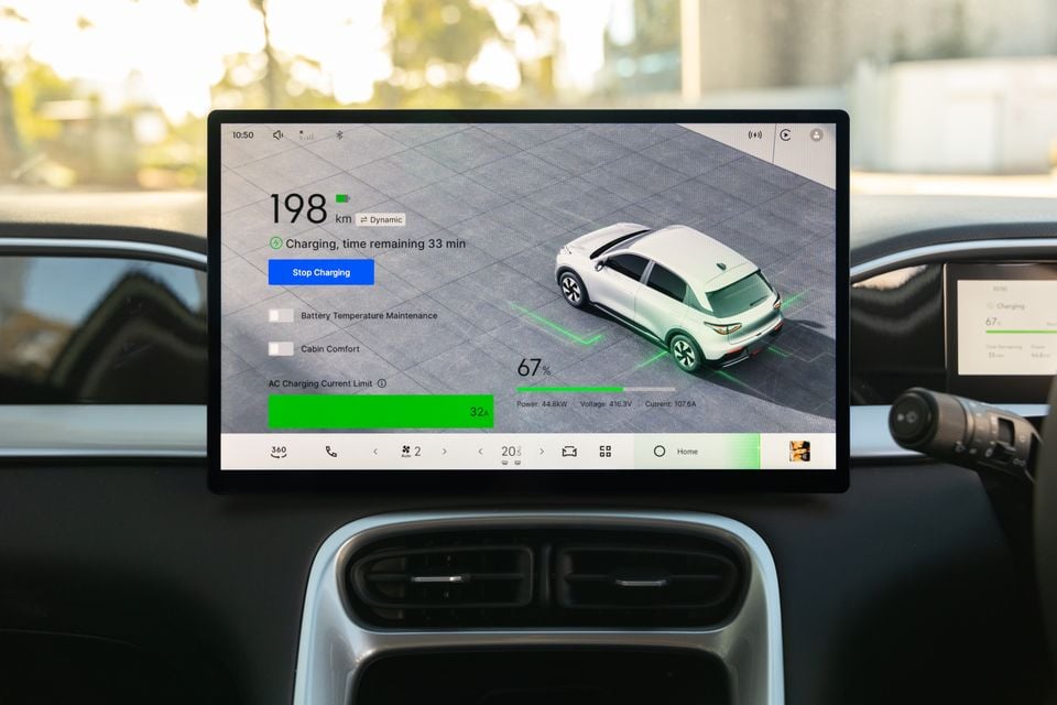 The infotainment touchscreen of a Geely EX2 displaying the EV charging status screen, showing 67% battery charge, 198km range remaining, and 33 minutes until full charge.