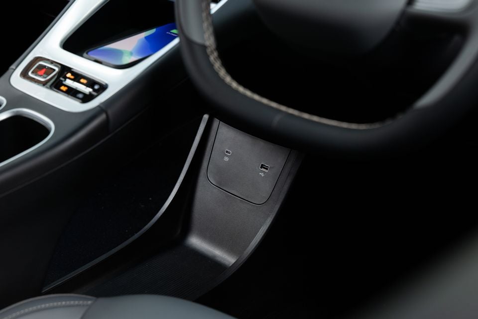Close-up of the centre console area in a Geely EX2 Inspire showing USB-C and USB-A charging ports, with the steering wheel and infotainment screen visible in the background.