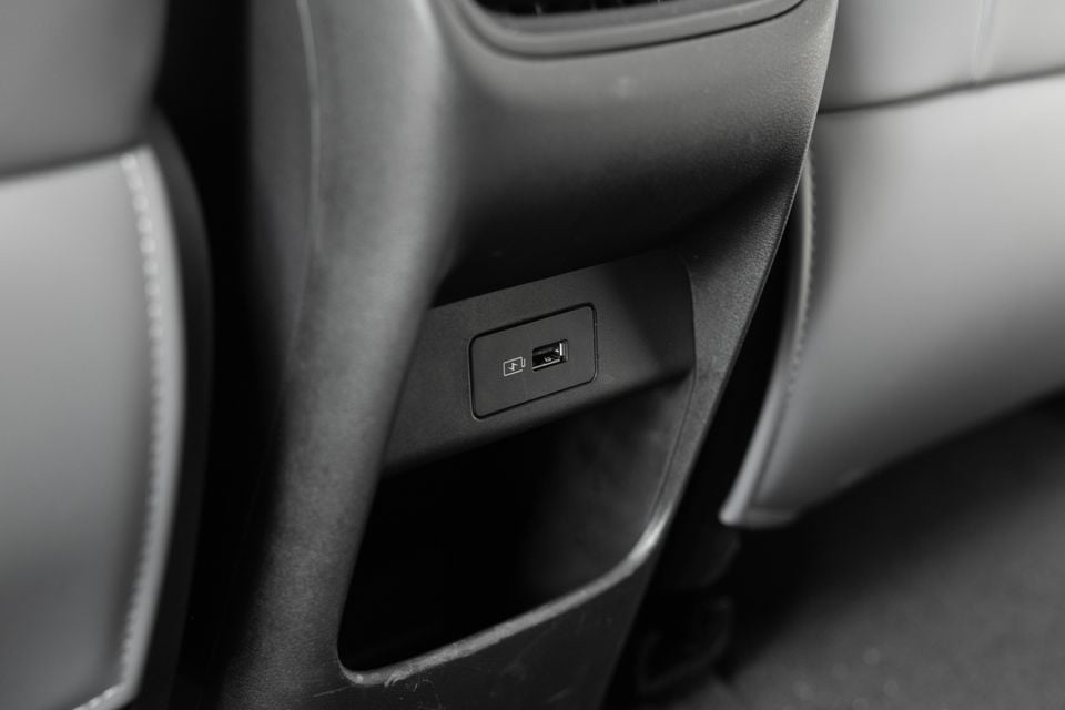 USB and USB-C charging ports on the rear centre console of a car interior