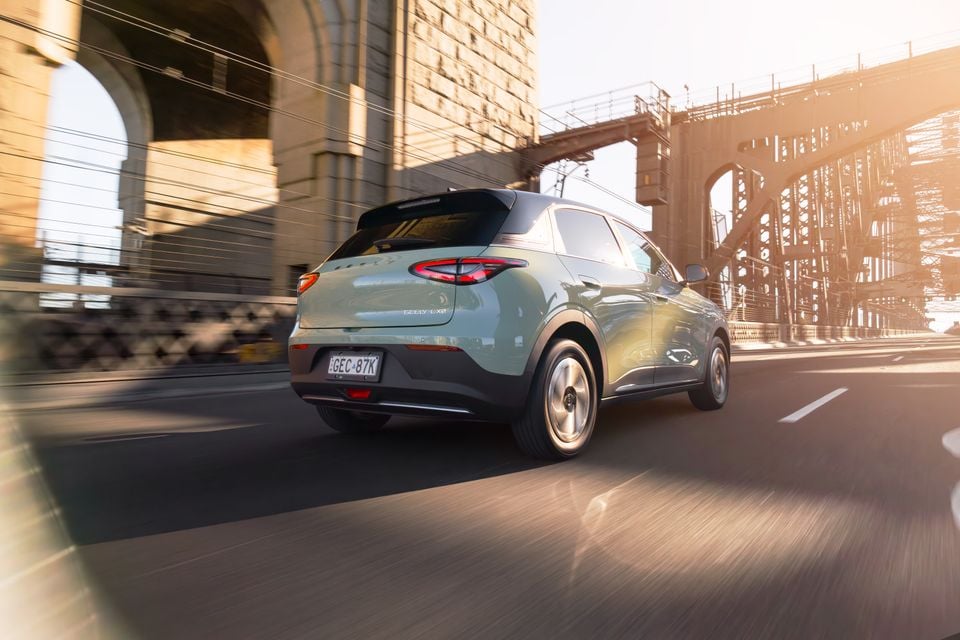 A green Geely EX2 SUV seen from the rear while driving across a bridge in Sydney