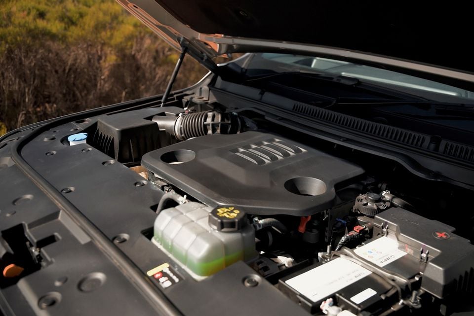 The engine bay of a 2026 GWM Cannon Alpha ute, shown with the bonnet open and the battery, coolant reservoir and engine cover visible.
