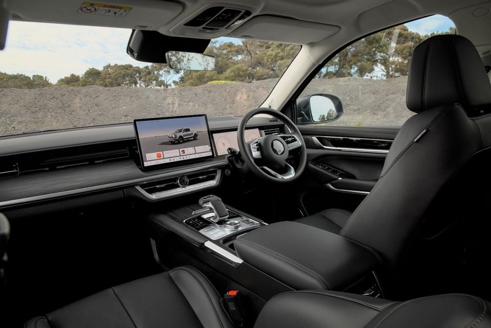 Interior view of a 2026 GWM Cannon Alpha ute, showing the black leather seats, steering wheel and dashboard with dual digital screens