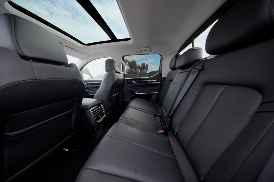 The black leather rear seats and panoramic sunroof of a 2026 GWM Cannon Alpha dual cab ute are shown from inside the cabin.