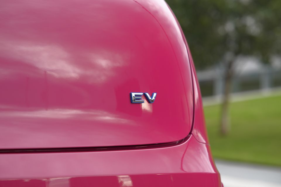Close-up of the 'EV' badge on the rear of a pink GWM ORA 5