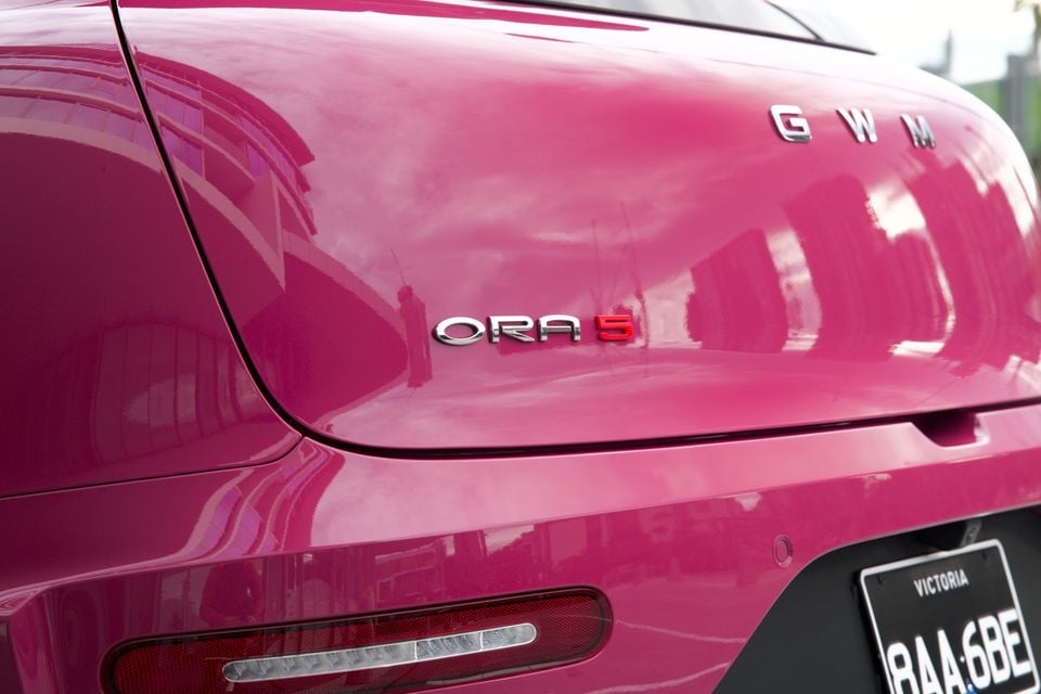 Close-up of the rear badge on a pink GWM ORA 5 SUV, showing the GWM and ORA 5 badging with a Victorian number plate visible