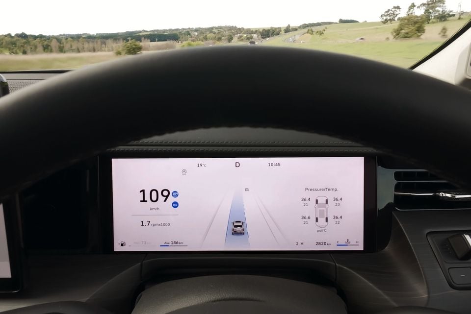 A digital instrument cluster in a 2026 GWM Tank 500 shows speed, adaptive cruise control and tyre pressure readouts while driving on a highway.