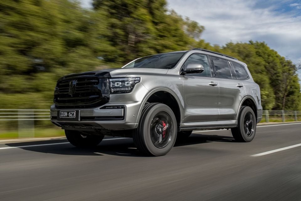 A silver 2026 GWM Tank 500 SUV driving on a highway, seen from the front quarter angle