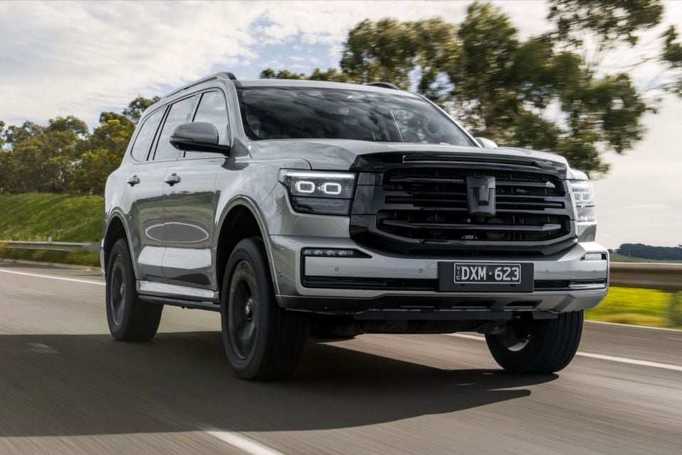 A silver 2026 GWM Tank 500 SUV driving on a highway, seen from the front quarter