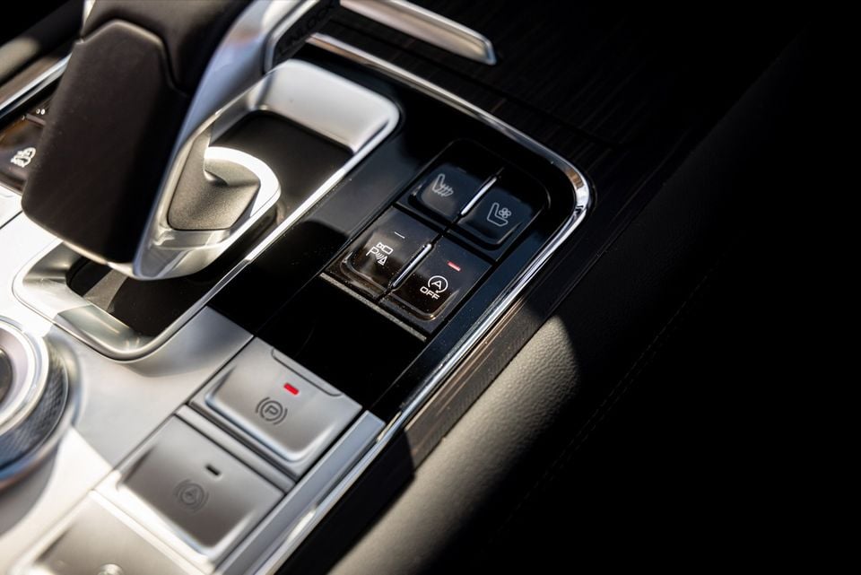 Close-up of the centre console controls in a 2026 GWM Tank 500, showing seat heating and ventilation buttons, parking brake and auto engine stop-start switches.