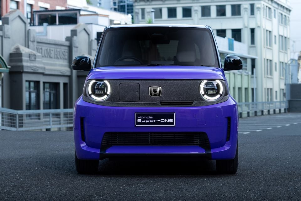 A purple 2026 Honda Super-ONE electric hatchback shown head-on, parked on a city street.