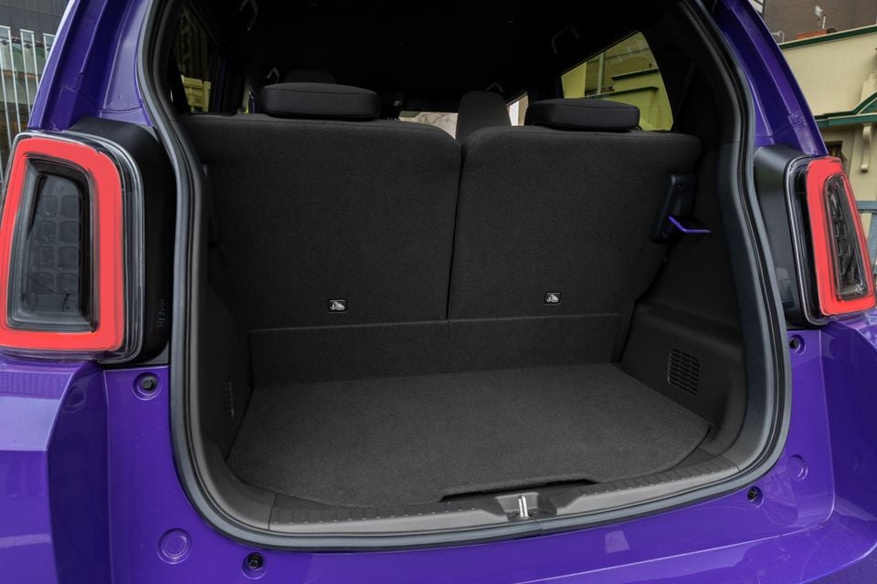 The open boot of a purple Honda Super One, showing the empty cargo area with rear seats folded upright.