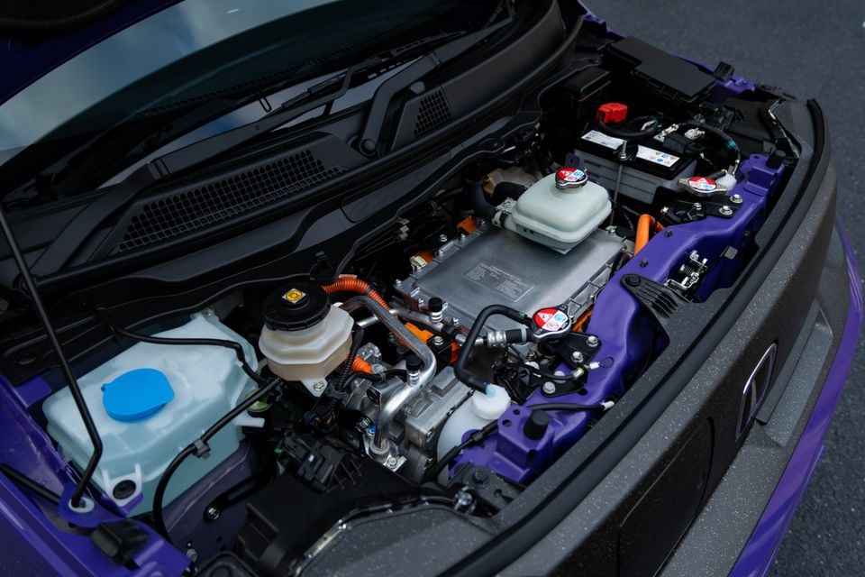 The engine bay of a purple 2026 Honda Super One electric vehicle, showing the electric motor, coolant reservoirs and battery.