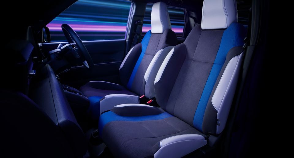 Front seats of the 2026 Honda Super One show blue and grey sport upholstery with white accents and a steering wheel visible.