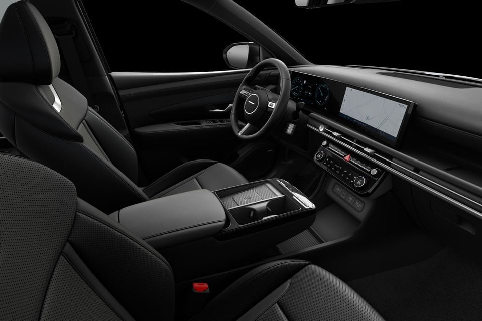 Interior of a 2026 Hyundai Tucson Hybrid showing the dashboard, steering wheel, centre console, and infotainment touchscreen with navigation displayed