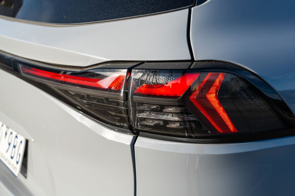 Close-up of the LED tail light on a silver 2026 Isuzu MU-X X-Terrain, showing arrow-shaped red light elements and smoked lens