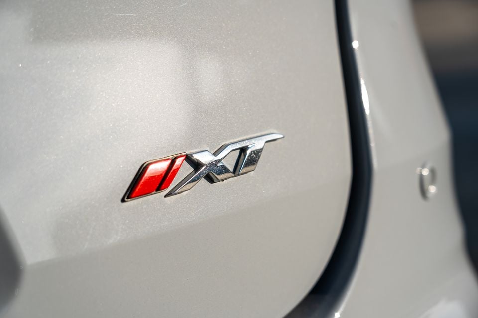 Close-up of the XT badge on the body panel of a silver 2026 Isuzu MU-X X-Terrain