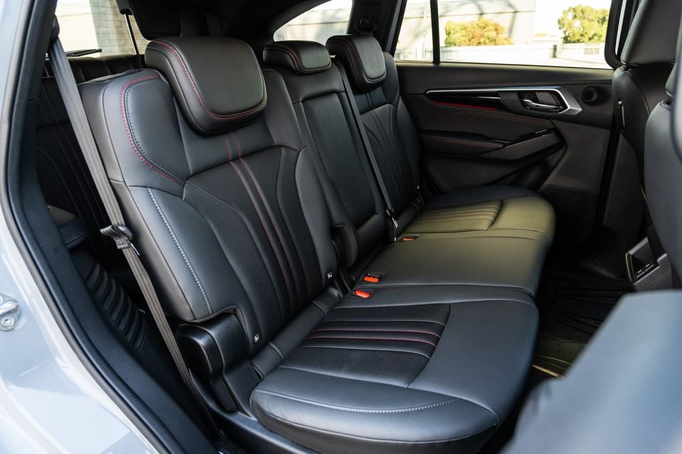 Rear seats of a 2026 Isuzu MU-X X-Terrain SUV, showing black leather upholstery with red contrast stitching across a three-seat bench