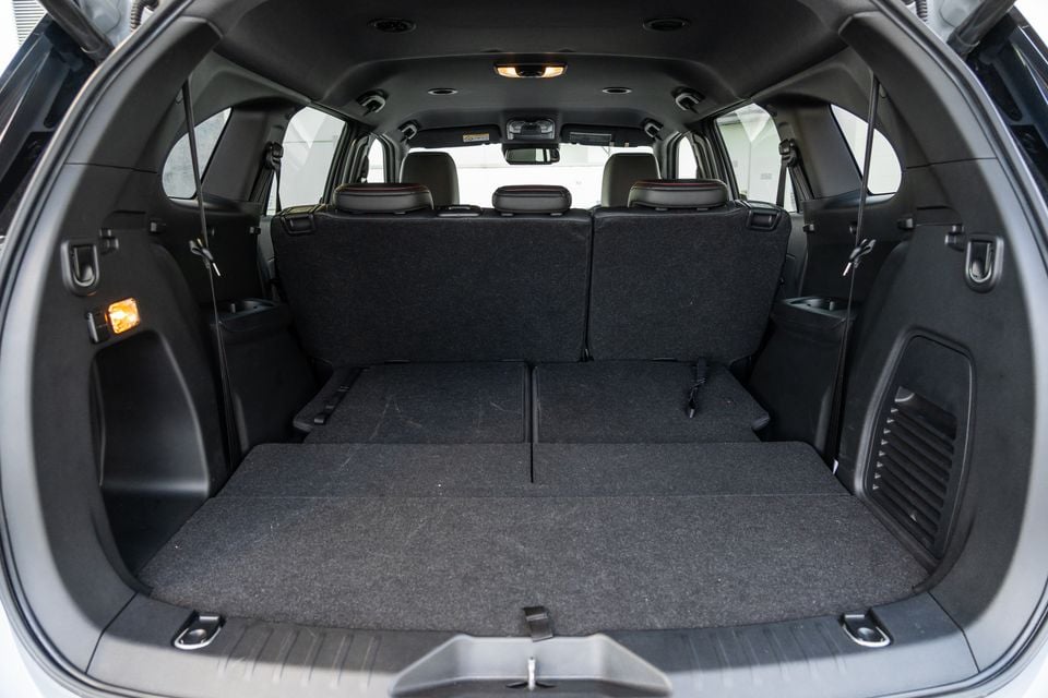 The boot of a 2026 Isuzu MU-X X-Terrain SUV, showing a large empty cargo area with the third row of seats folded flat and dark carpet lining throughout.