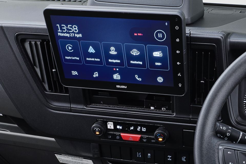 Close-up of the touchscreen infotainment display and climate controls in an Isuzu truck's dashboard, showing Apple CarPlay and Android Auto icons.