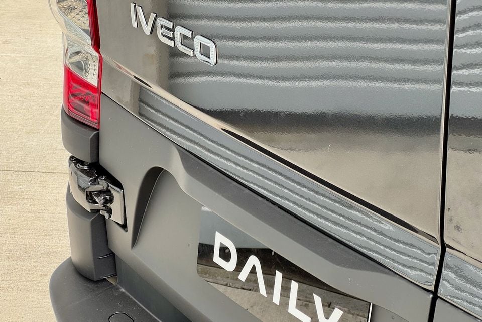 Close-up of the rear of an Iveco Daily van showing the Iveco and Daily badging, tail light, and door latch