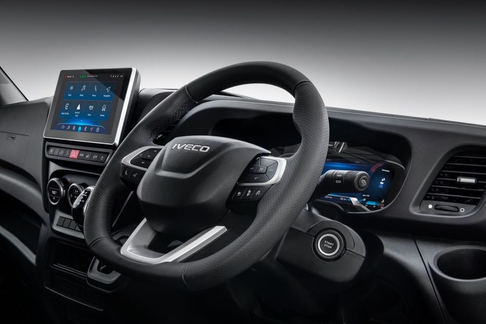 Iveco Daily interior showing the leather-wrapped steering wheel, touchscreen infotainment system with Apple CarPlay and Android Auto, digital instrument cluster, and push-button start