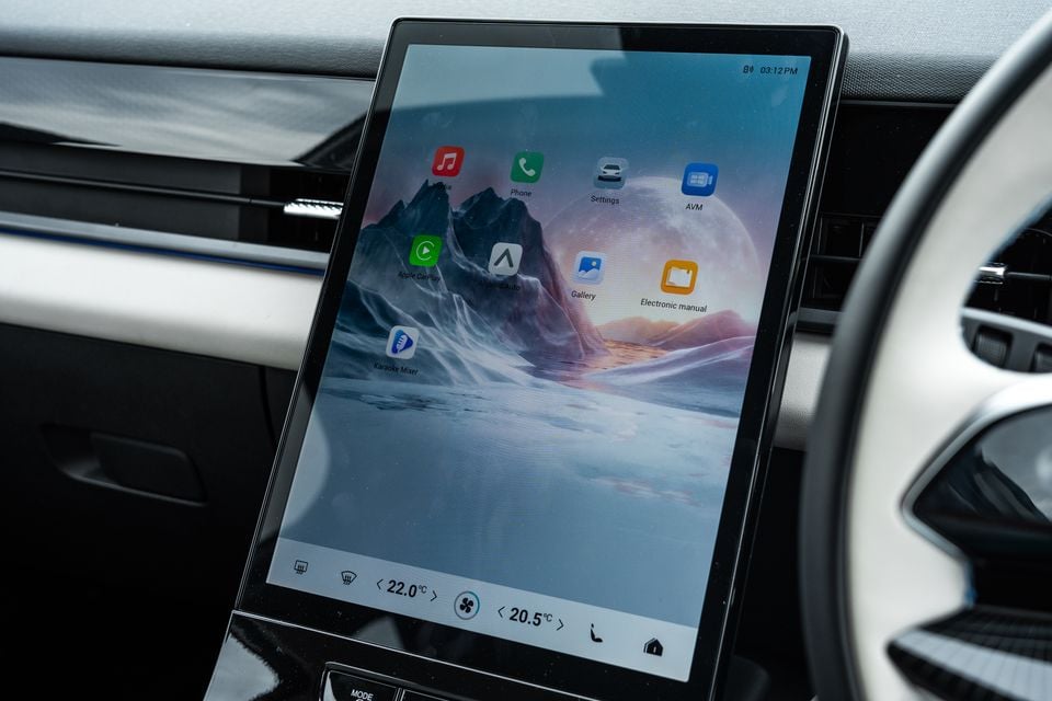 The large portrait-oriented touchscreen infotainment display of a 2026 Jaecoo J5 EV, showing app icons including Apple CarPlay, Android Auto, Phone, and Karaoke Mixer, with climate controls at the bottom.