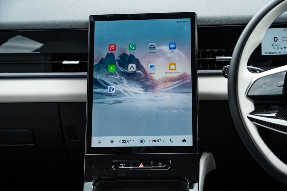 The large portrait-orientation touchscreen infotainment display of a 2026 Jaecoo J5 EV, showing the home screen with apps including Apple CarPlay, Android Auto, and Karaoke Mixer, with climate controls at the bottom.