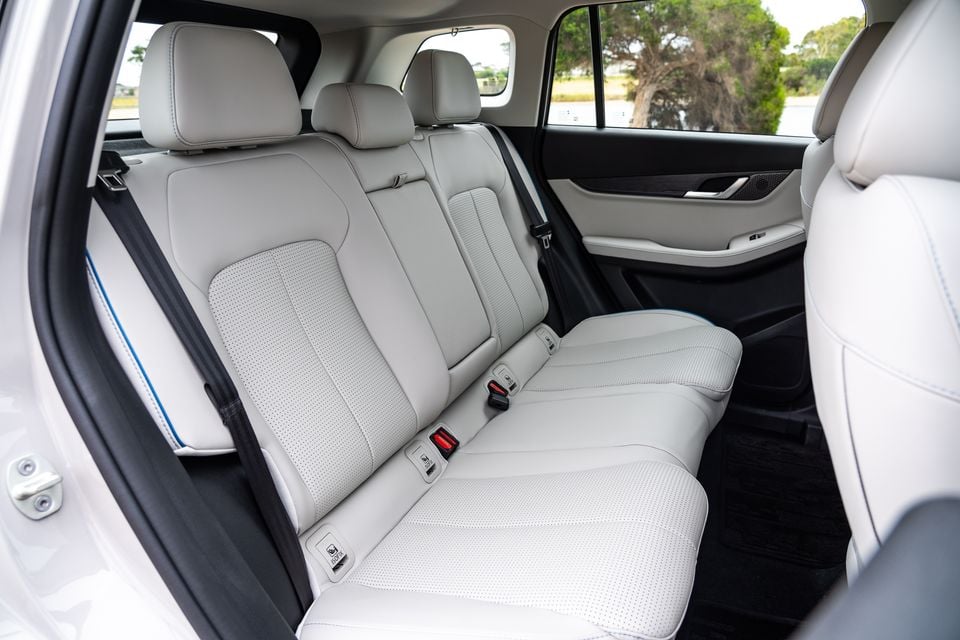 Rear interior of a 2026 Jaecoo J5 EV showing light grey perforated leather rear seats with seatbelts and door trim