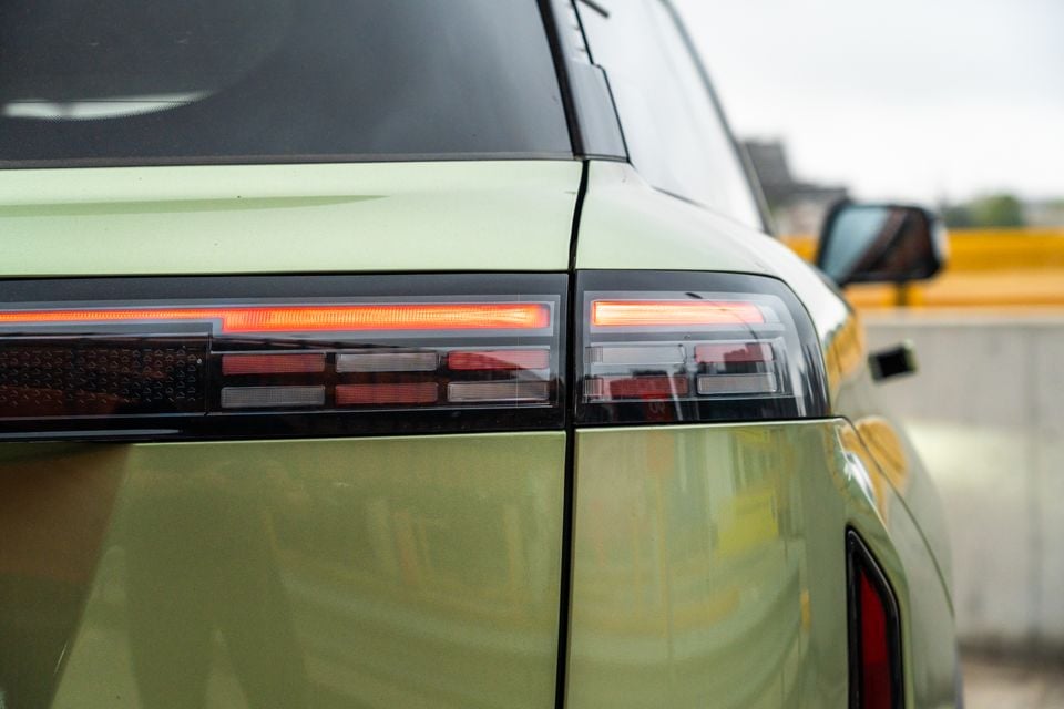 Close-up of the illuminated LED tail lights on a green 2026 Jaecoo J7 SUV, seen from the rear