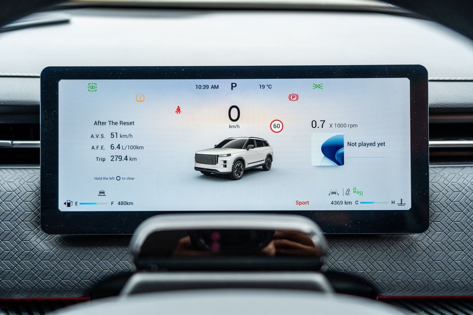 The digital instrument cluster of a 2026 Jaecoo J7 SUV displaying speed, trip data, fuel level, and a 3D vehicle graphic on its widescreen display.