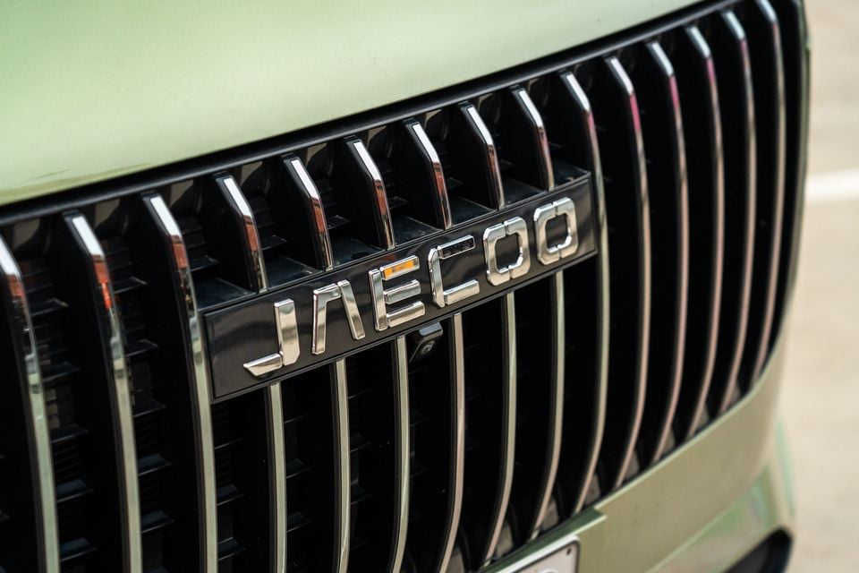Close-up of the Jaecoo name badge on the front grille of a light green Jaecoo J7