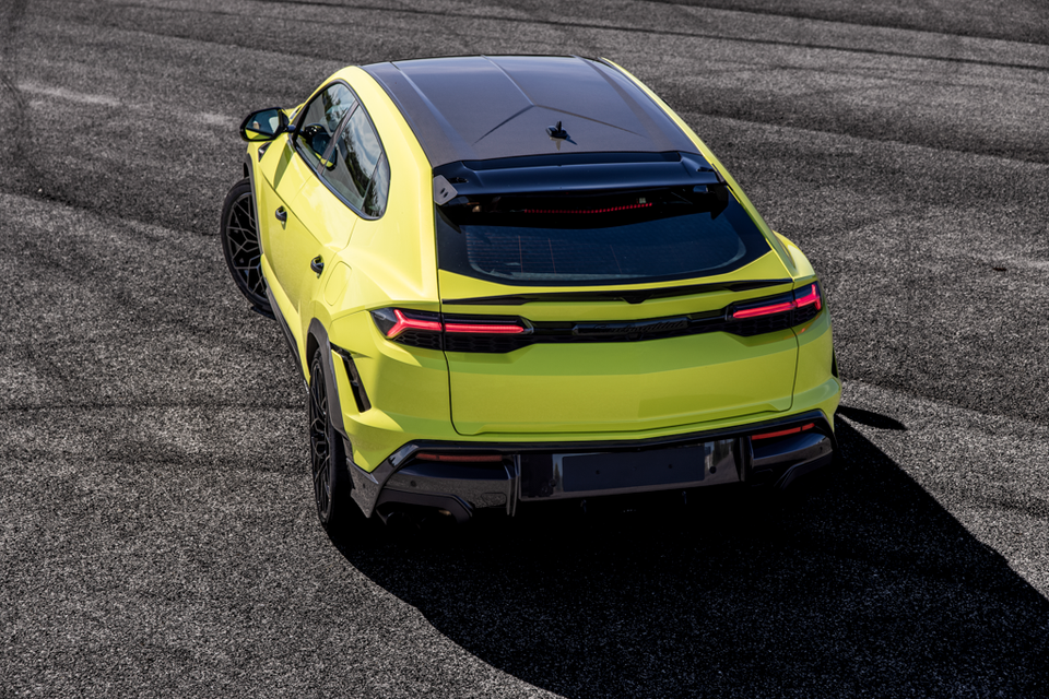 A yellow-green 2026 Lamborghini Urus Performante SUV seen from above and behind on a track surface