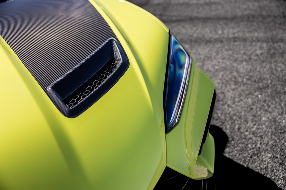 Close-up of the yellow-green bonnet vent and headlight on a Lamborghini Urus Performante, featuring a carbon fibre insert with hexagonal mesh detailing