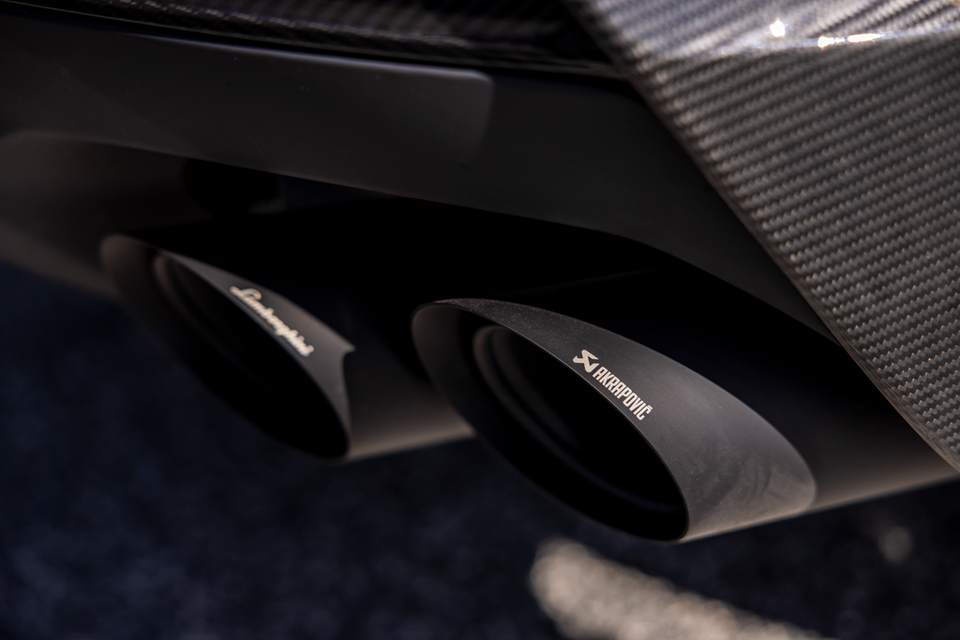 Close-up of dual Akrapovic exhaust tips on a Lamborghini Urus Performante, framed by a carbon fibre rear diffuser