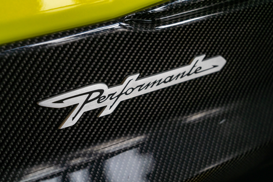 Close-up of the Performante badge on a carbon fibre panel of a yellow-green Lamborghini Urus Performante