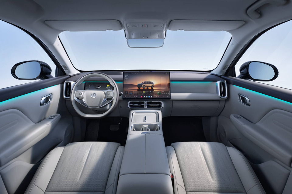 Interior view of the 2026 Leapmotor B10 showing the dashboard, large central touchscreen infotainment display, steering wheel, and light grey seats