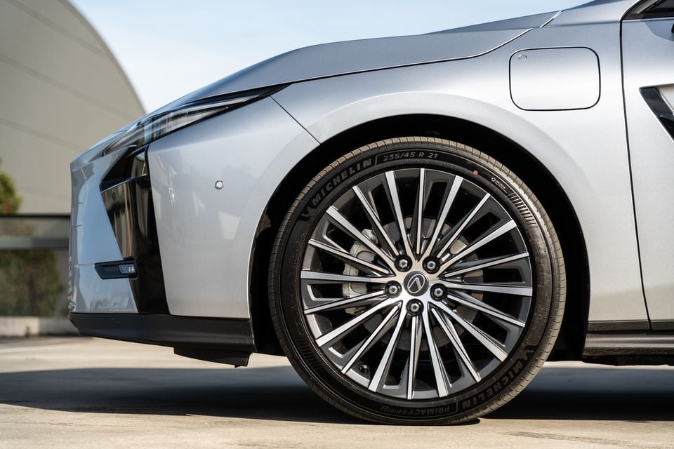 Close-up of the front wheel on a silver 2026 Lexus ES 350e, showing a multi-spoke alloy wheel with a Michelin Primacy e·Energy 235/45 R21 tyre