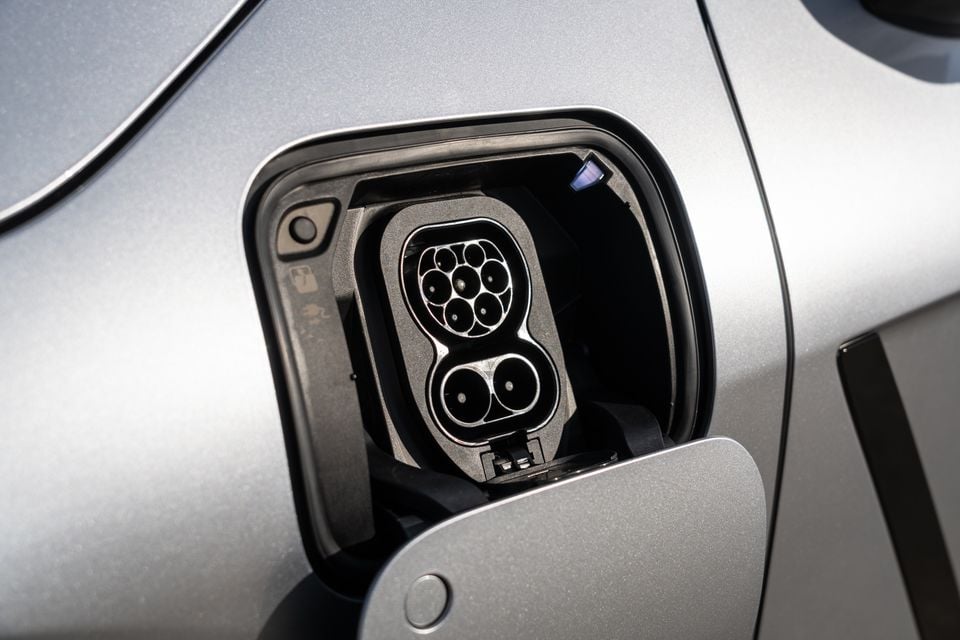 Close-up of the CCS Type 2 charging port on a silver 2026 Lexus ES350e, with the charge door open