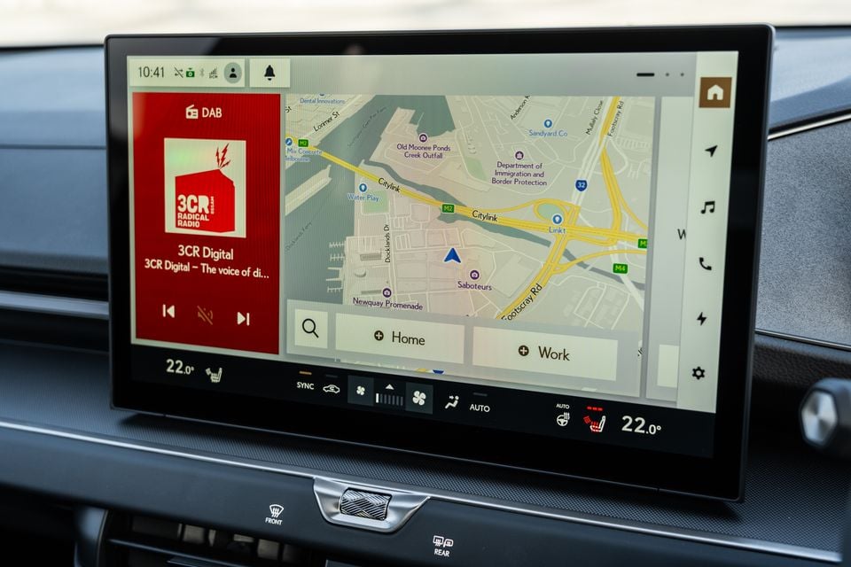 A car infotainment touchscreen showing a split view of DAB radio tuned to 3CR Digital and a navigation map of Melbourne's Docklands area, with climate controls visible below