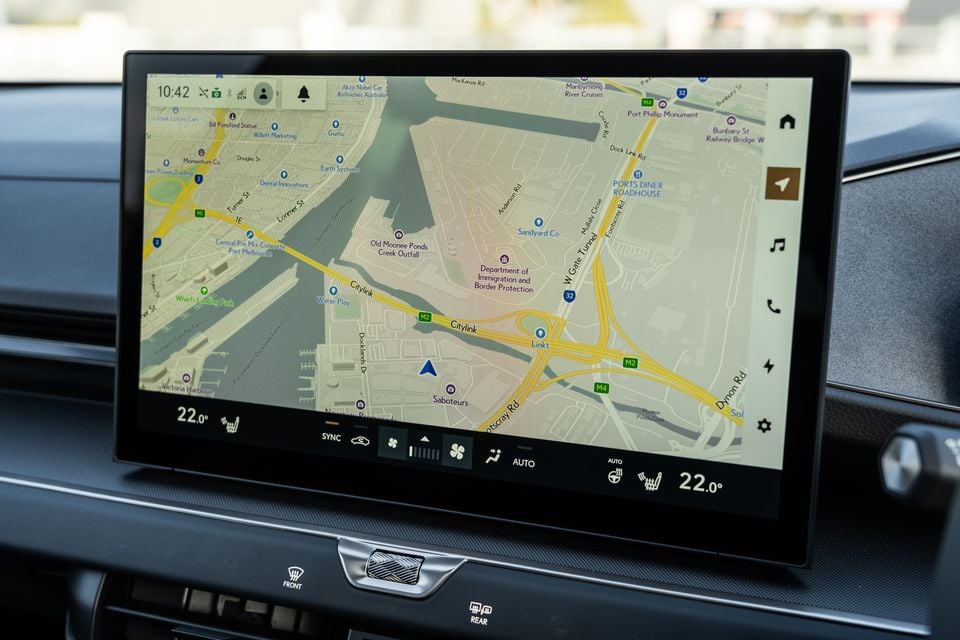 A large touchscreen infotainment display in a Lexus ES showing a navigation map of Melbourne's Docklands area, with climate controls visible below
