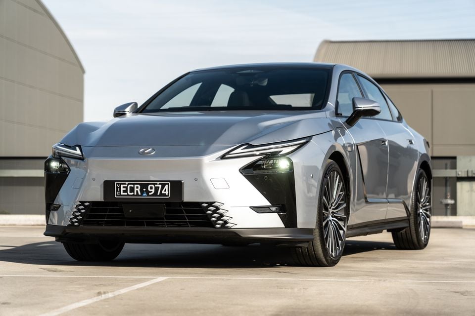 A silver 2026 Lexus ES 350e sedan seen from the front at a low angle in a car park