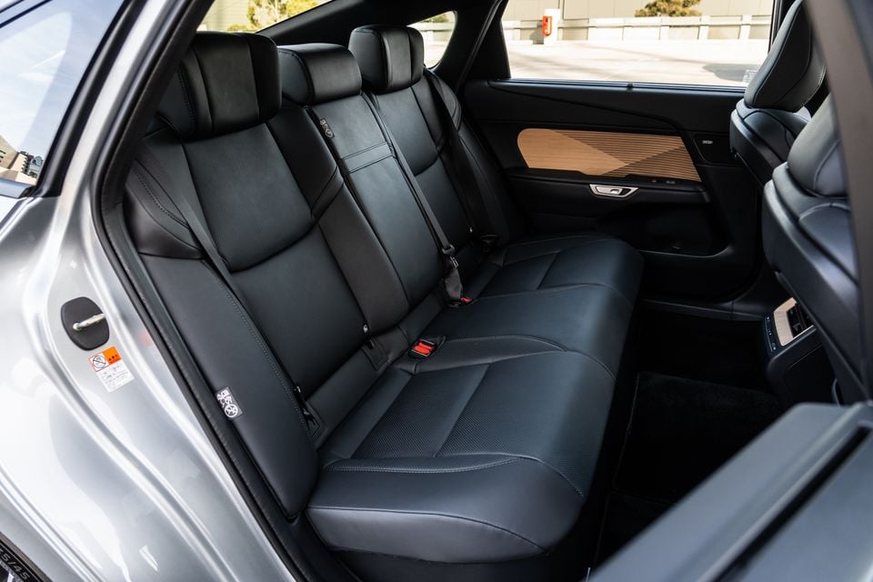 Rear interior of the 2026 Lexus ES350e Sports Luxury showing black leather rear seats with wood trim accents